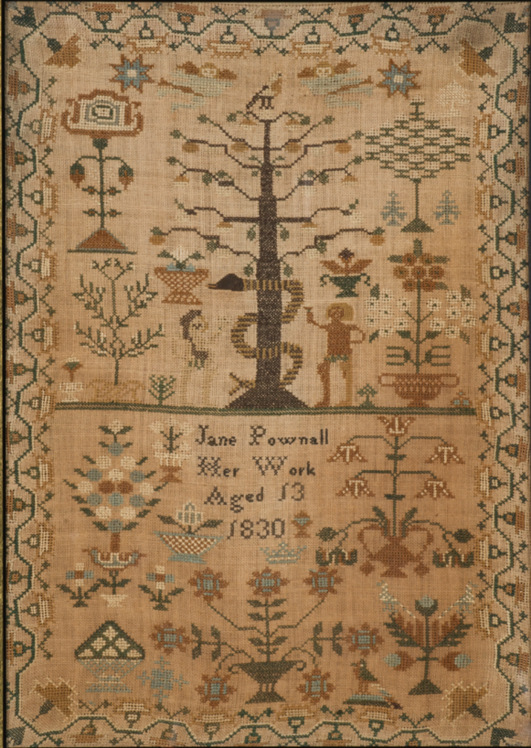 Embroidered sampler with figures of Adam and Eve standing on either side of a tall tree with a snake wrapped around it; under the tree are the words, “Jane Pownall, Her Work, Aged 13, 1830.”