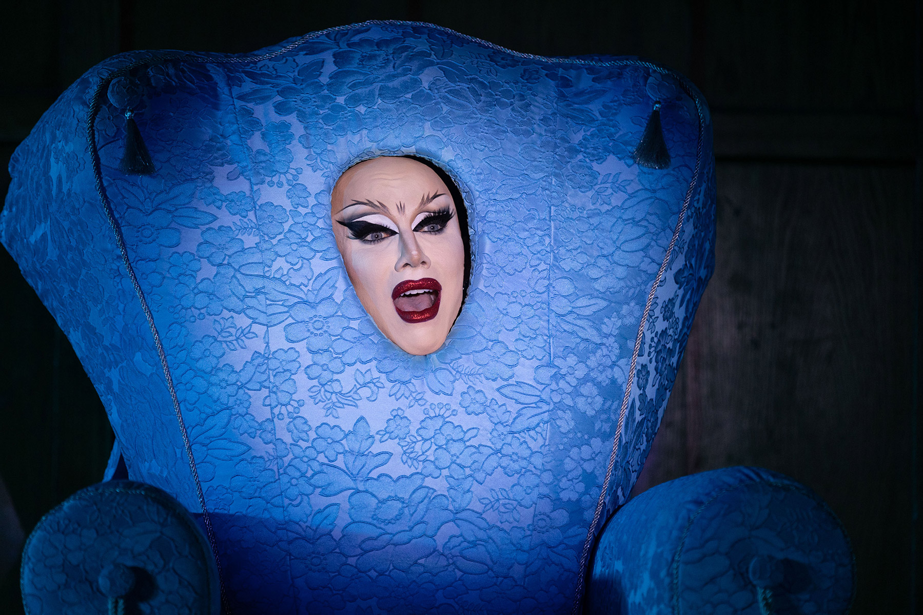 Woman with her face coming out of a blue decorated box.