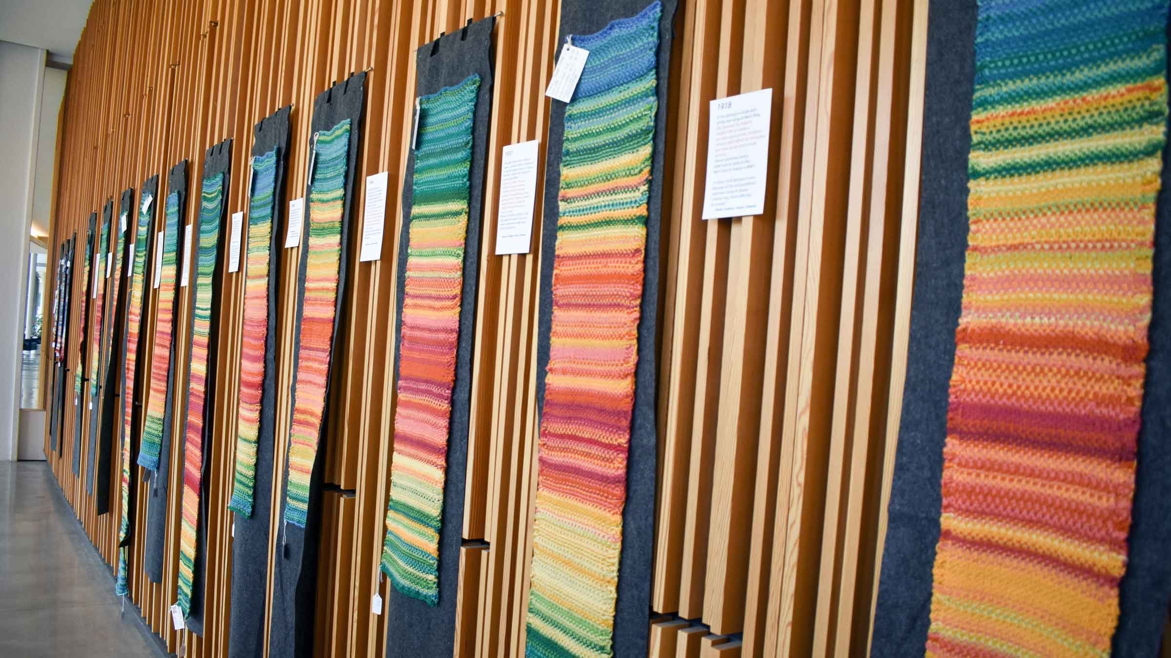 Knitted multicolored tapestries hanging on a wall