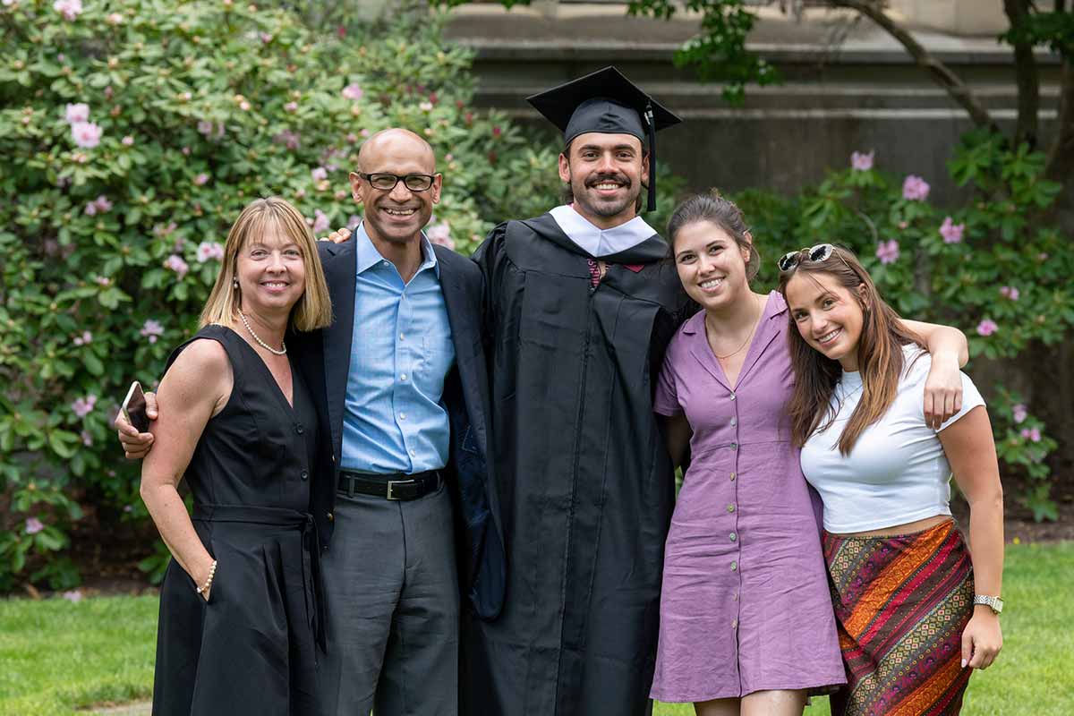 A family stands together, arms around each other's shoulders, after the ceremony.