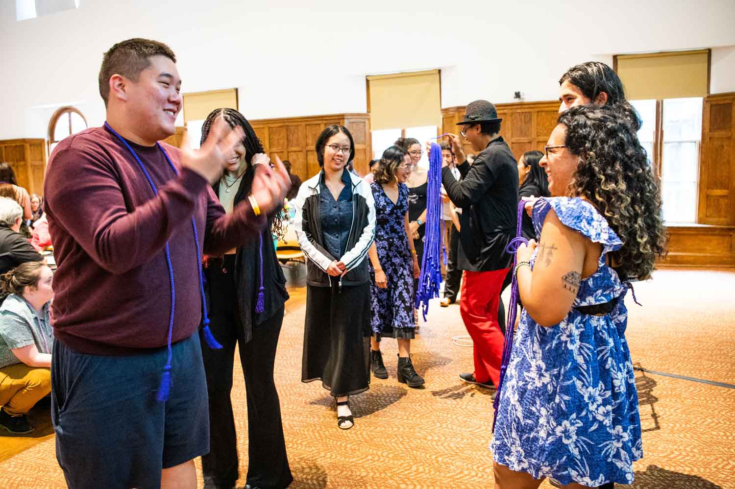 ceremony where people are waiting in line to receive a purple transition cord