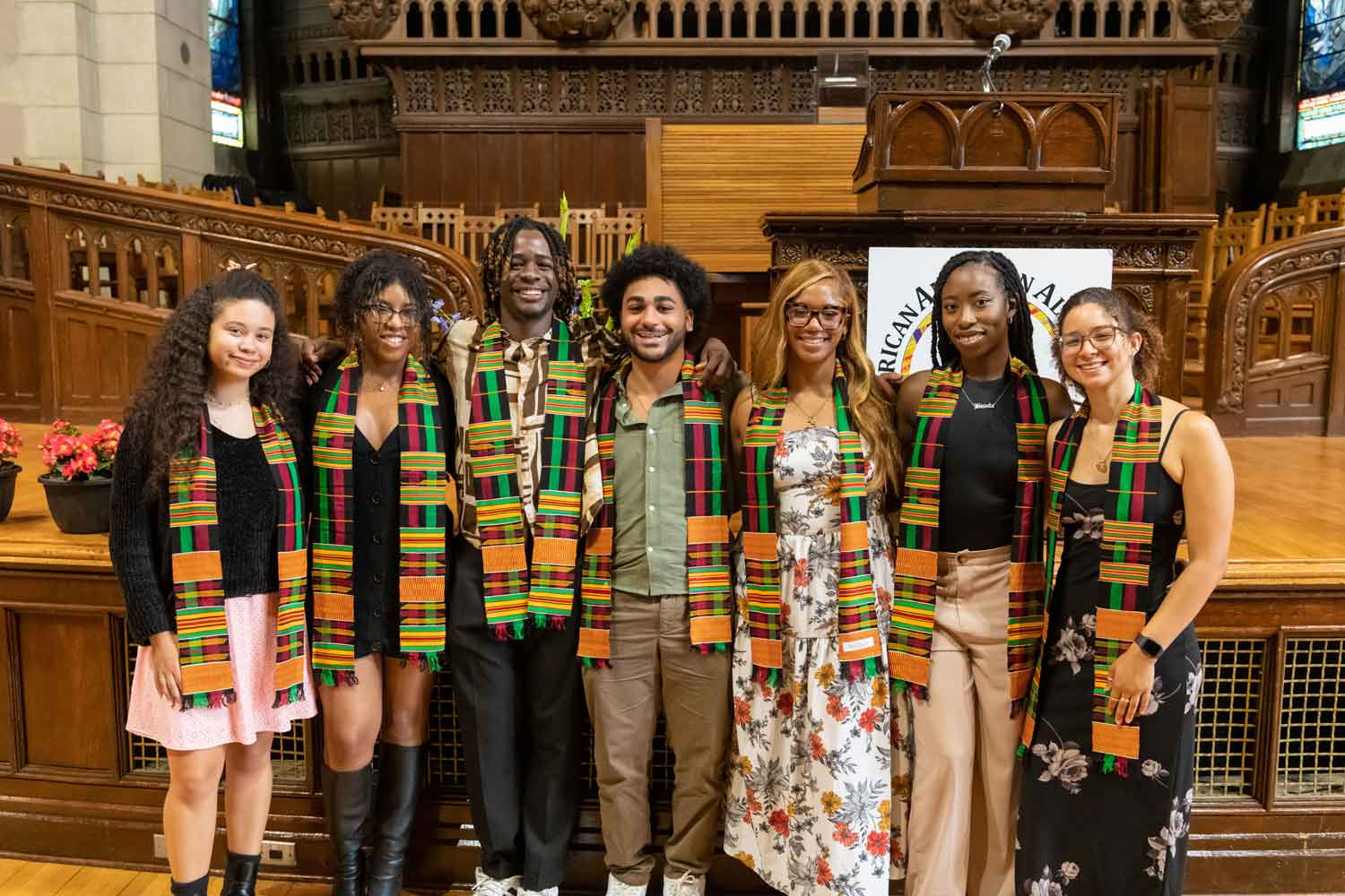 group of ceremony attendees posing with their kente cloths