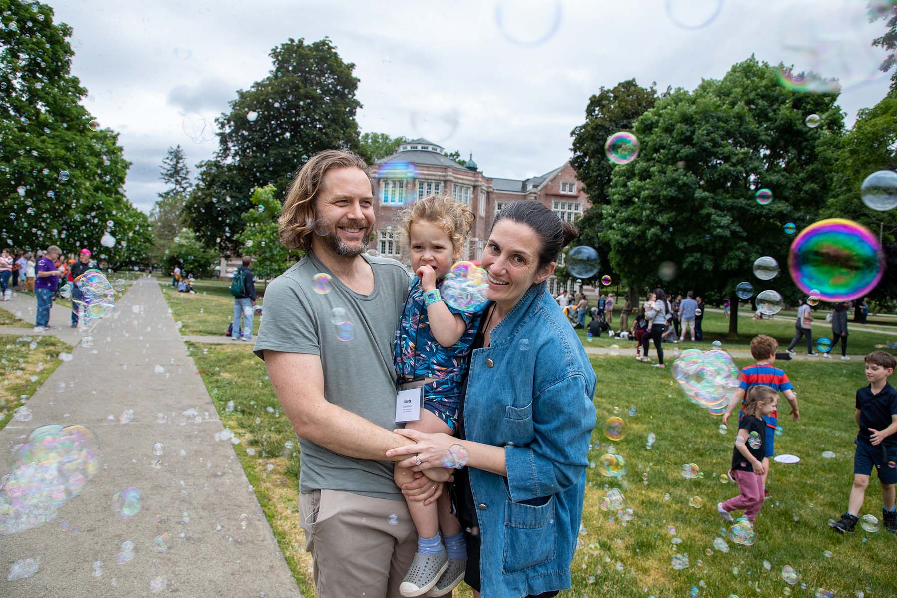 Man and woman holding a girl surrounded by bubbles