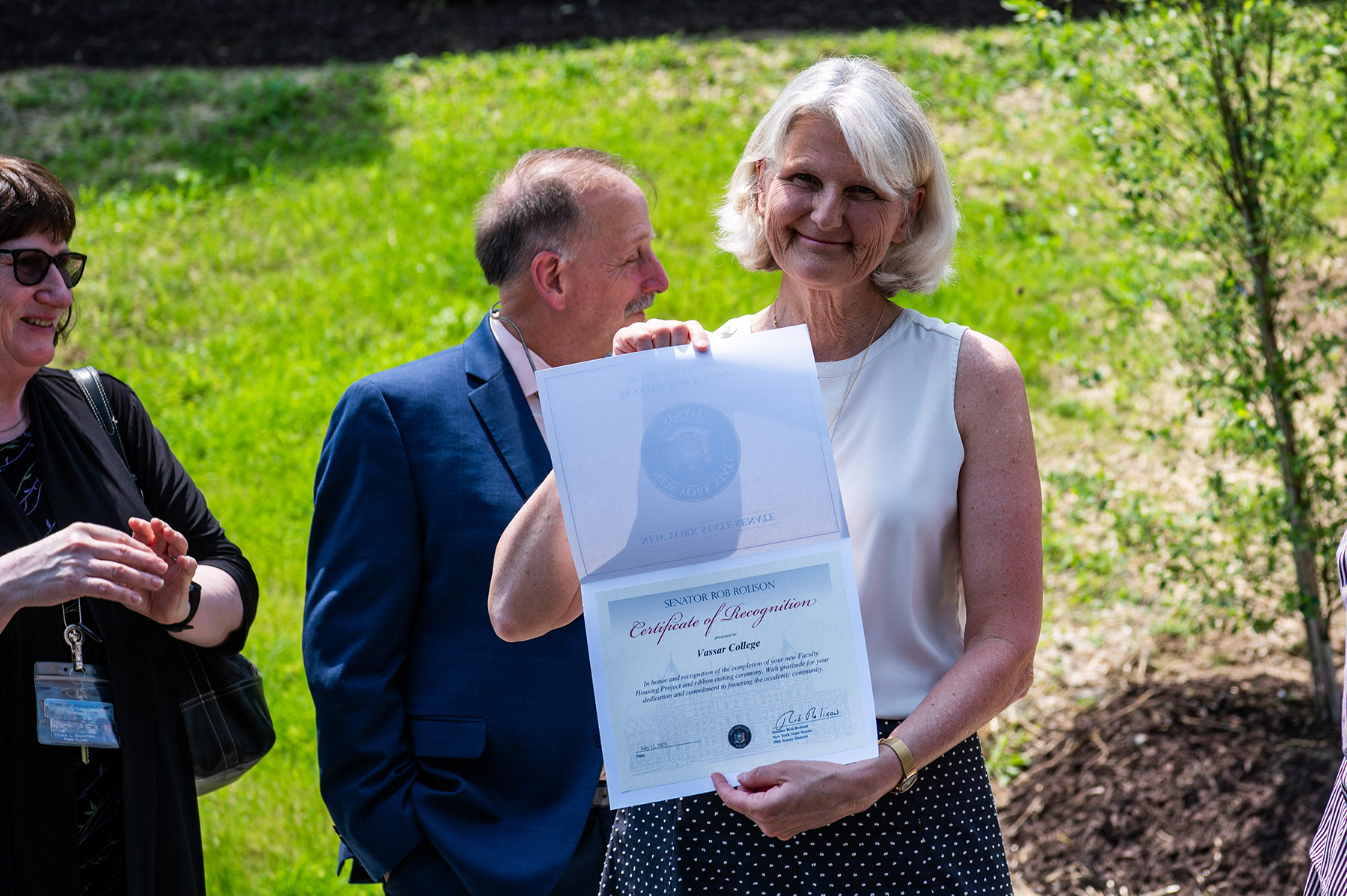 President Bradley holding a certificate while smiling for the camera.