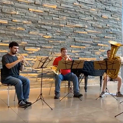Three musicians playing instruments in the Bridge Building.