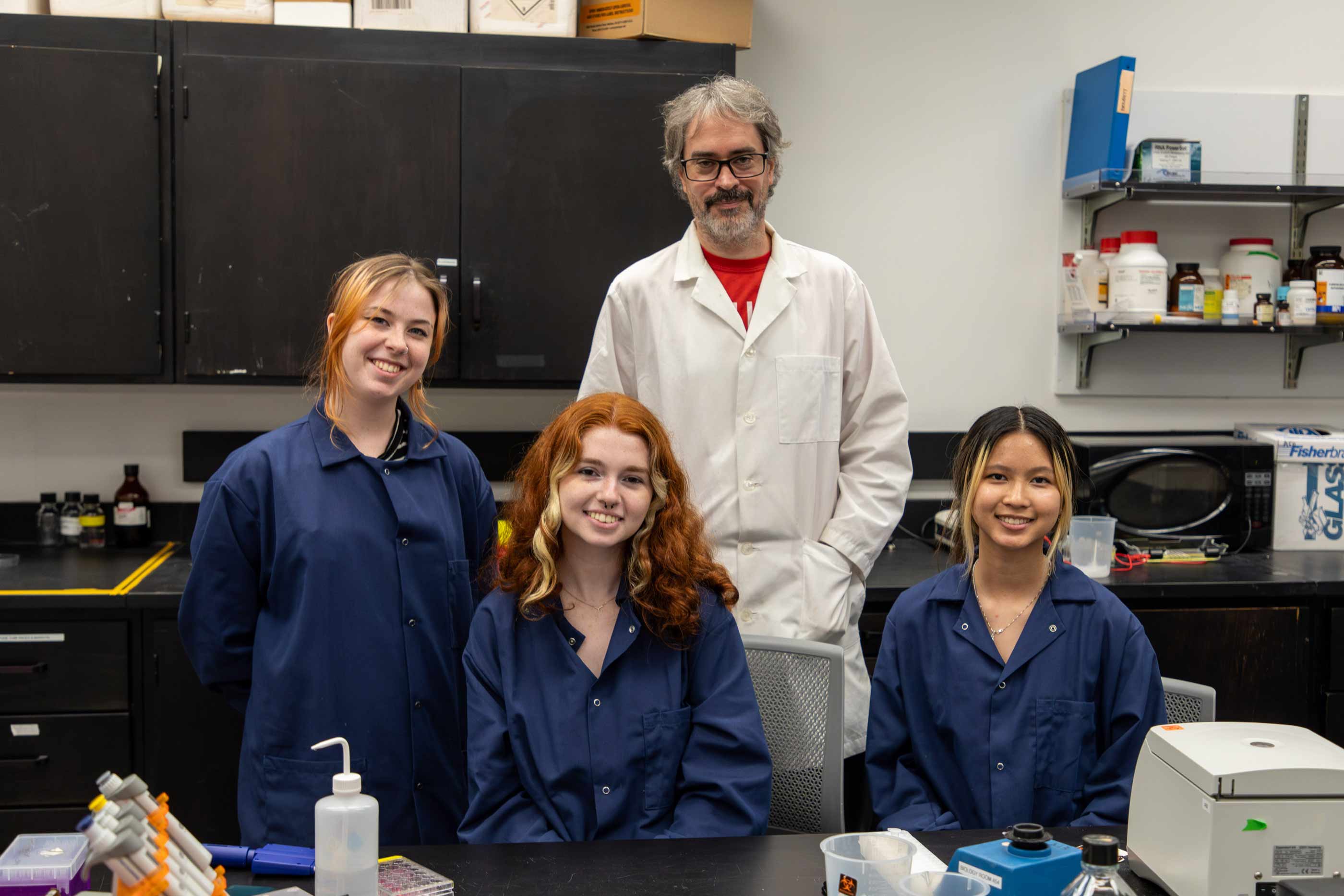 Brynn Conrad ‘24 , Autumn Cullinan ‘25, Sharon Luong ‘26, and Professorm of Biology Davis Esteban posing in a lab.
