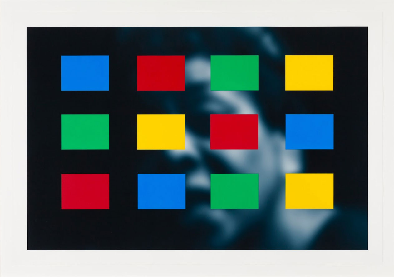 Art work with a black and white photo of a face in the background and a grid of yellow, blue, green, and red rectangles partially obscuring the photo in the foreground