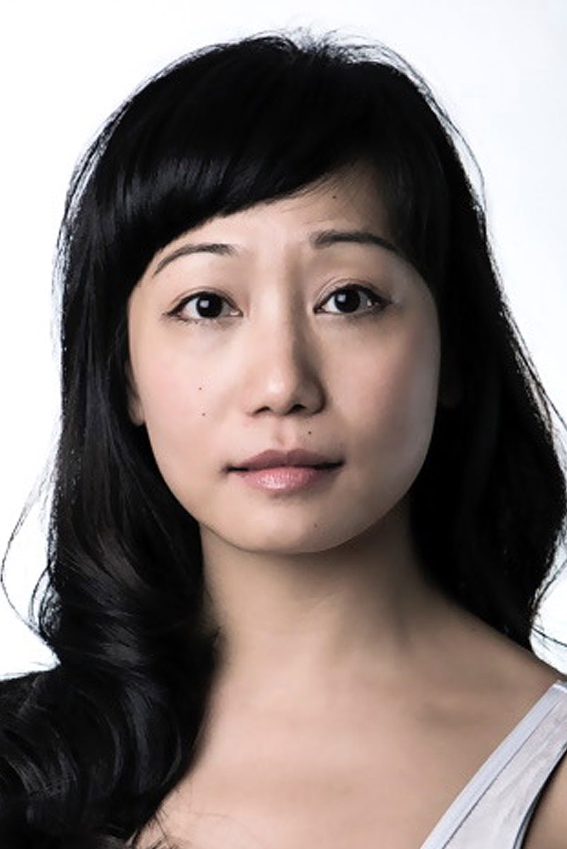 A portrait of a person with long black hair looking at the viewer.