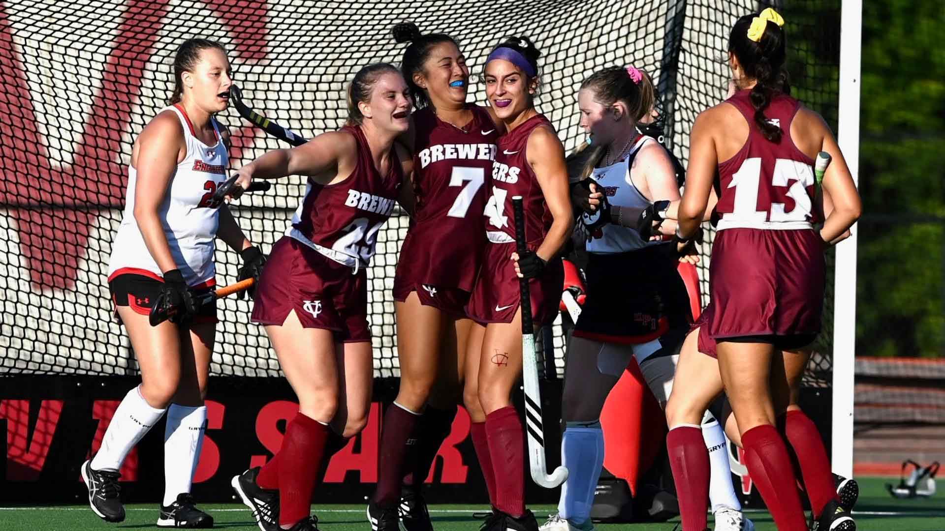 Vassar field hockey team celebrating in front of a goal