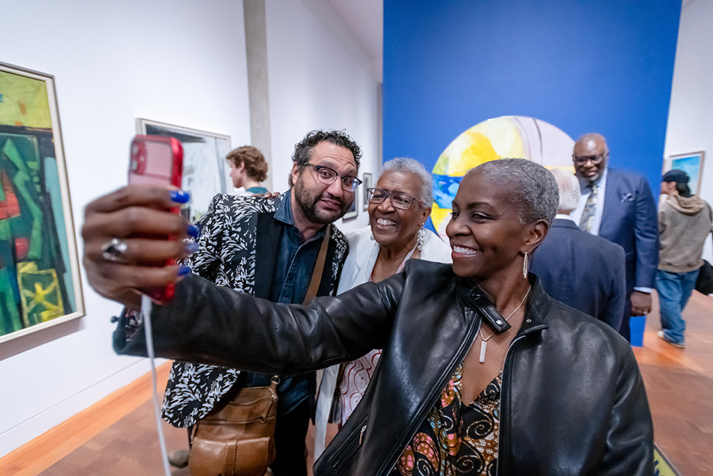 A person taking a selfie with two other people.