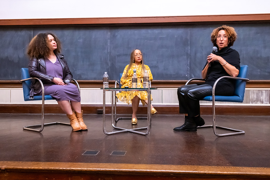 Three people sitting around a table in a panel discussion.