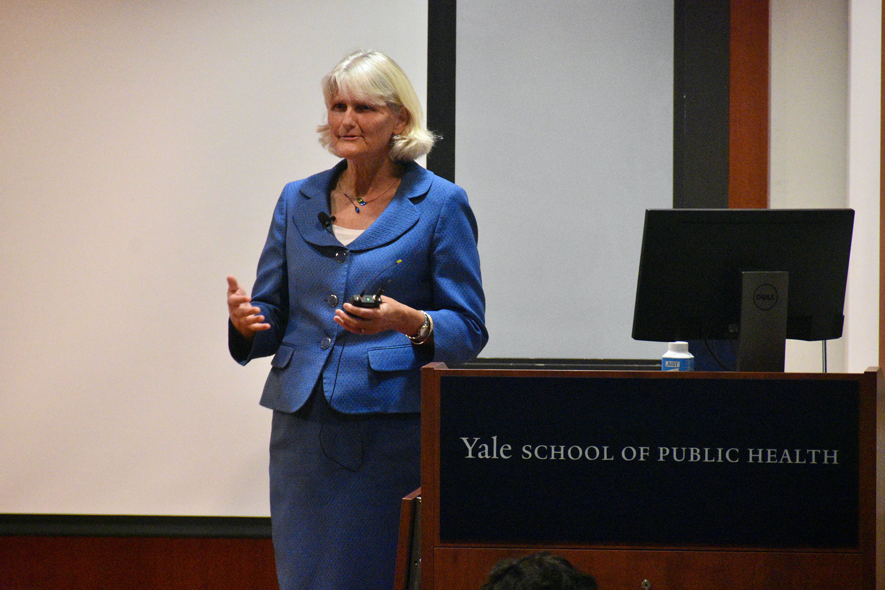 Pictured: Elizabeth Bradley. Person lecturing in front of a podium with the writing, "Yale School of Public Health."