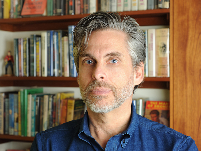Portrait of Michael Chabon with bookshelves in the background