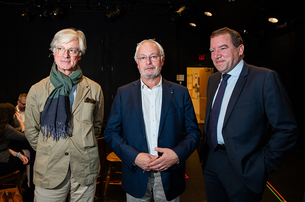 Three men stand together facing the camera.