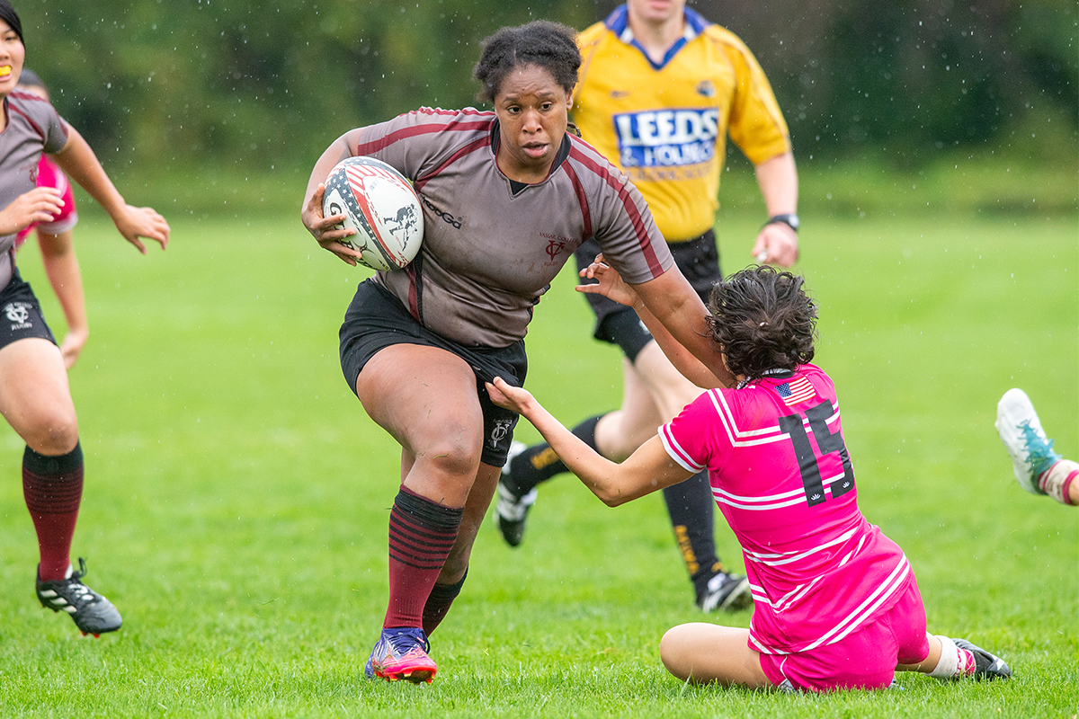 action shot of rugby player Asia Baker running with the ball