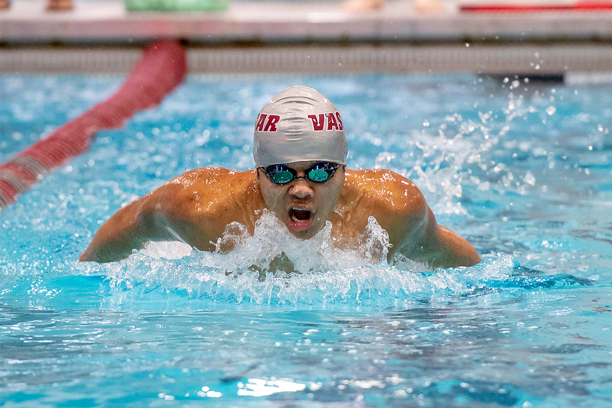 Closeup of Lucas Juaregui, wearing swim cap and goggles, racing in the pool