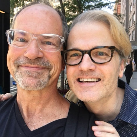 Two people smiling with their heads together.