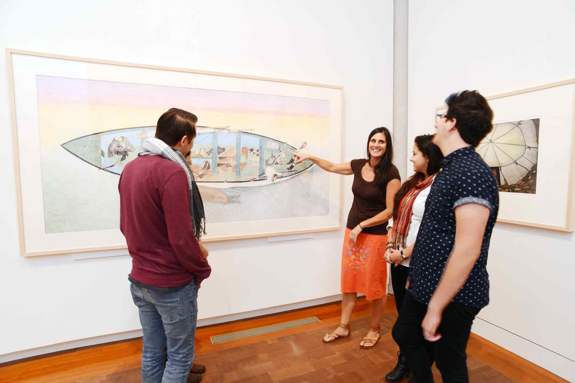 People in an art gallery discussing a work on the wall.