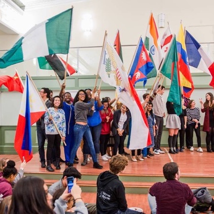 A large room with a lot of people and many different national flags.