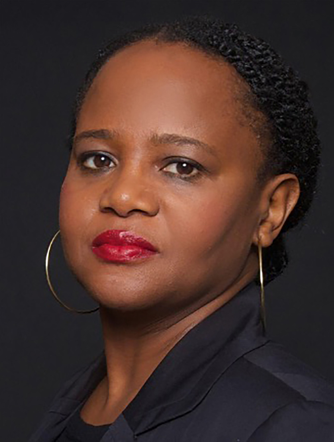 Edwidge Danticat wearing a black shirt and large hoop earrings.