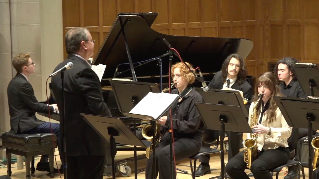 Performance with the conductor in the foreground and musicians in the background