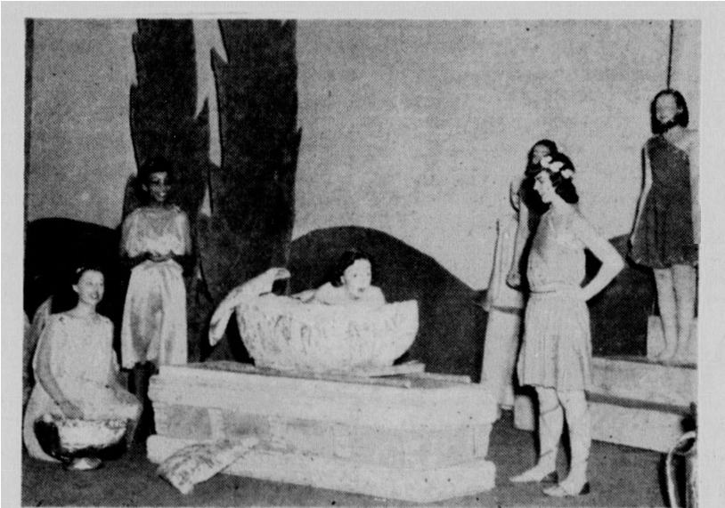 A black and white photo of several students putting on a theatrical performance.