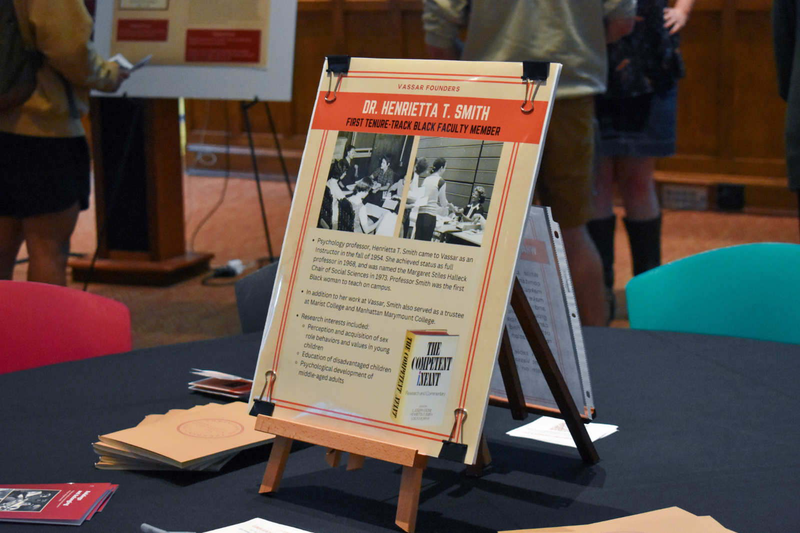A poster placed on a table. The poster reads “Dr. Henrietta T. Smith, First Tenure-track Black Faculty Member”.