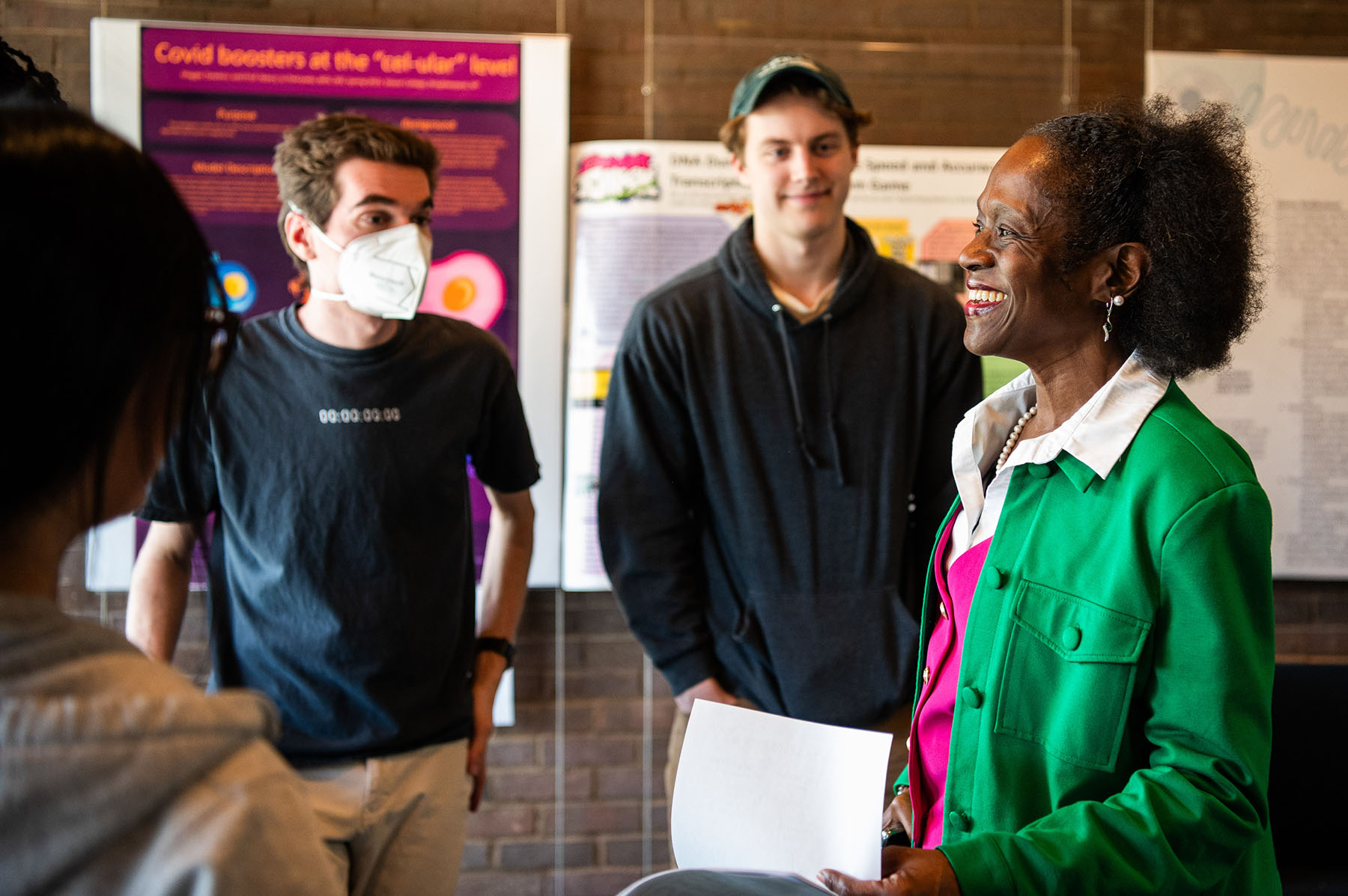 Woman holding some papers speaking to a group of people. 