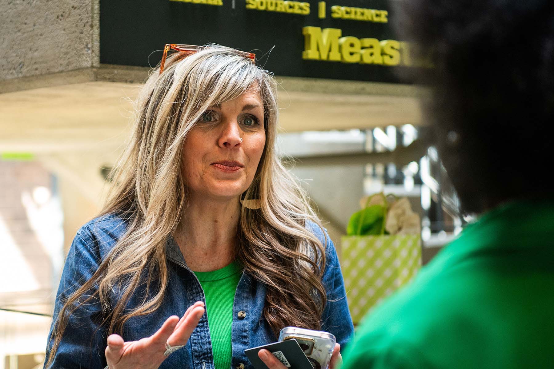 Michelle Olson, Executive Director of Evergreen Minds, wearing a green shirt under a denim collared shirt. 