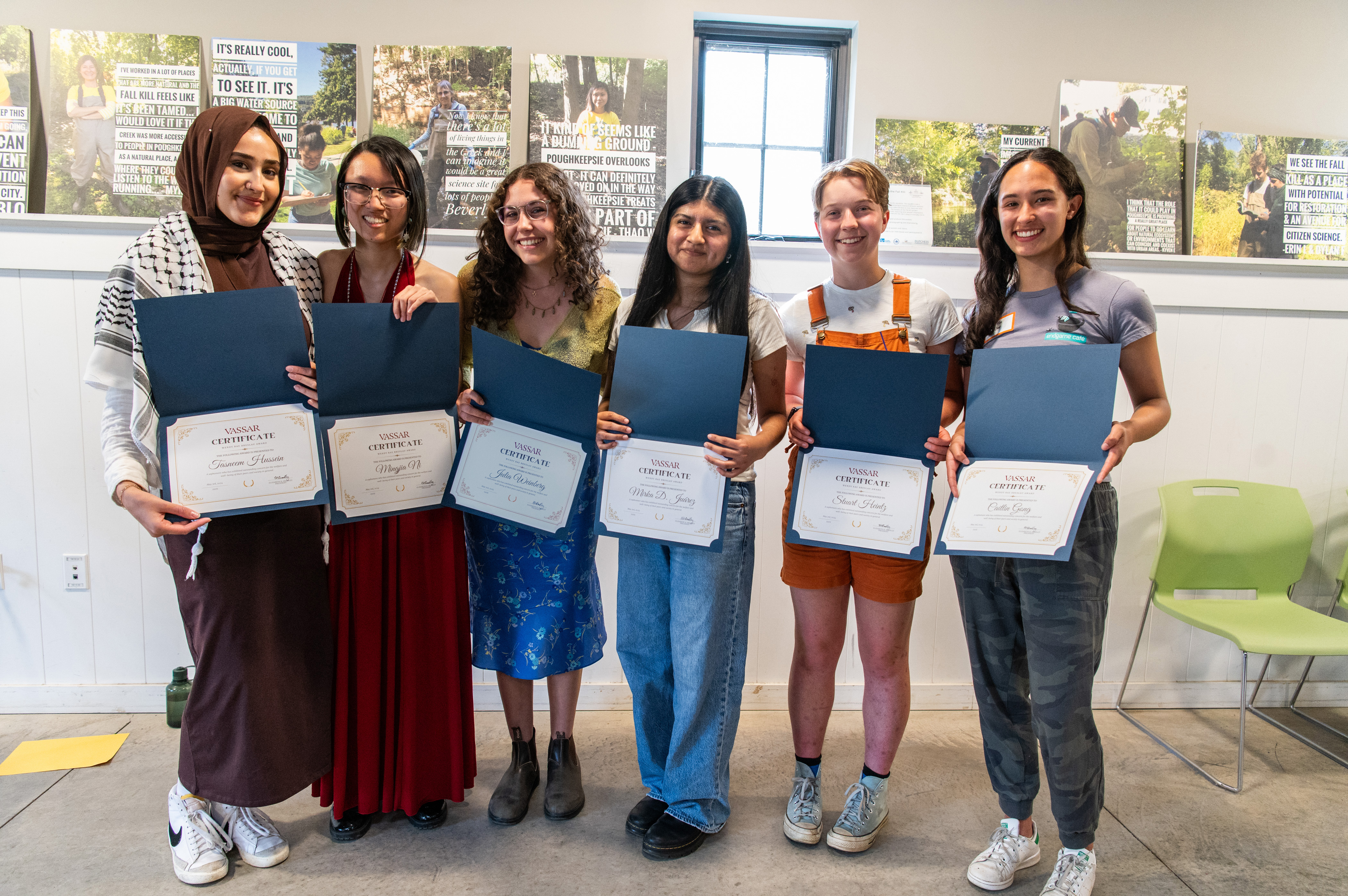 Six people holding diploma/awards and smiling.
