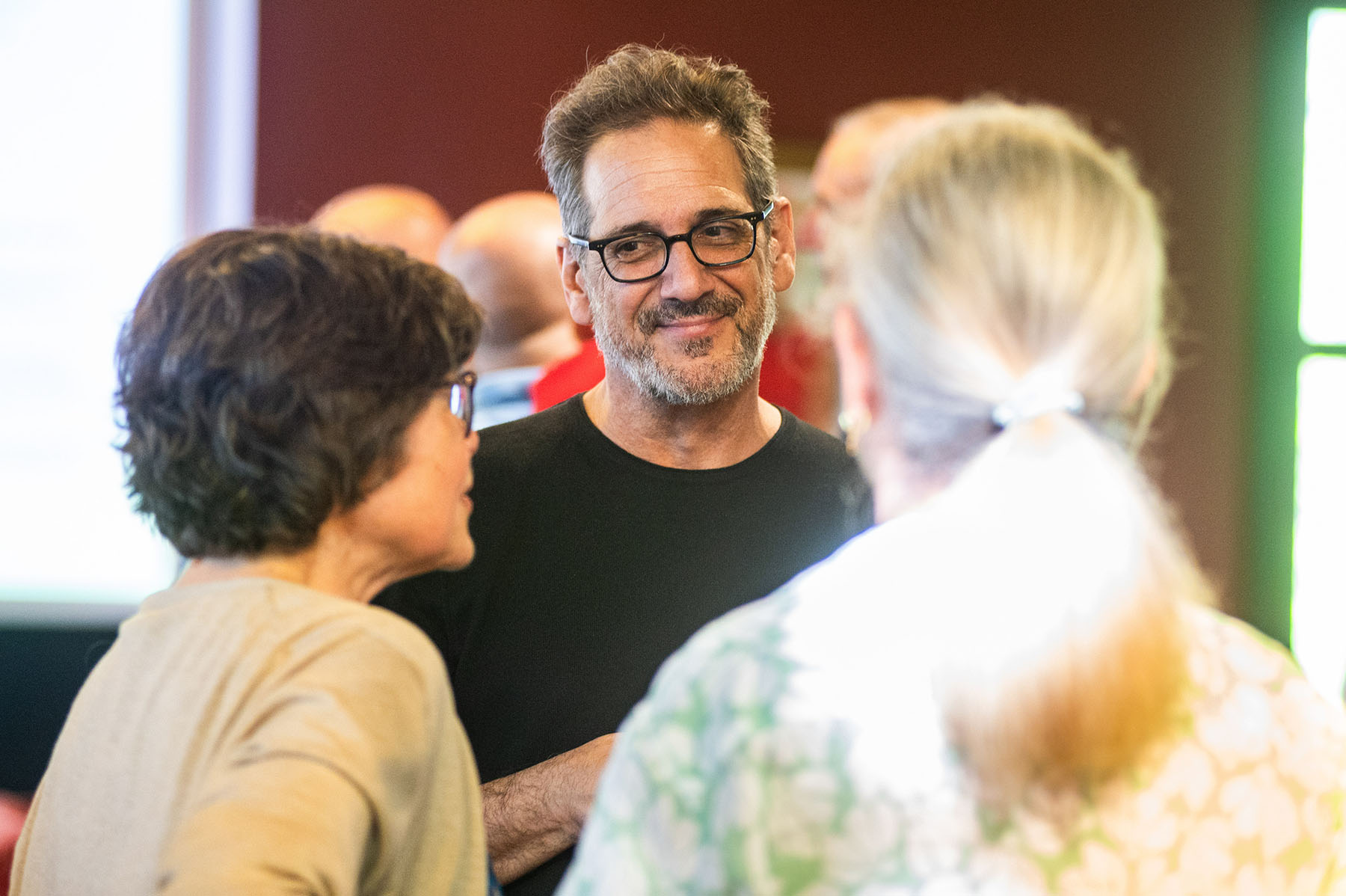 Professor of Anthropology Thomas Porcello engaging in conversation with attendees at an event.