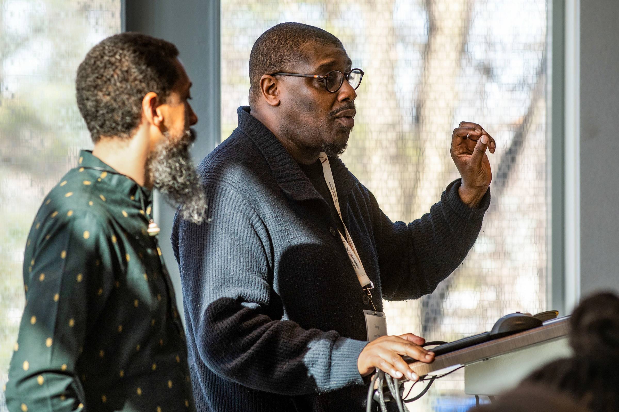 Two people standing behind a lectern, one speaking.