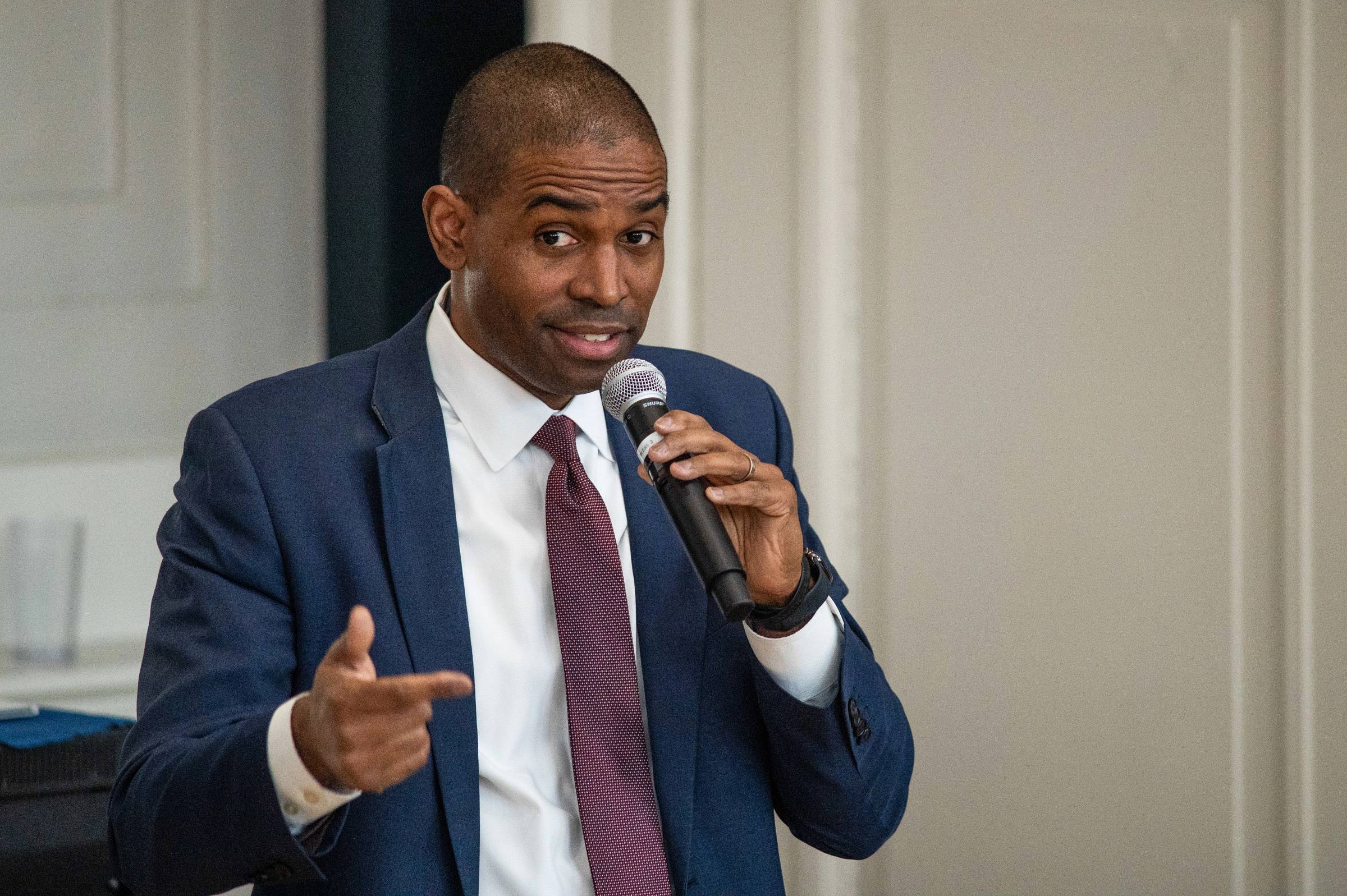 Person holding a microphone and speaking.
