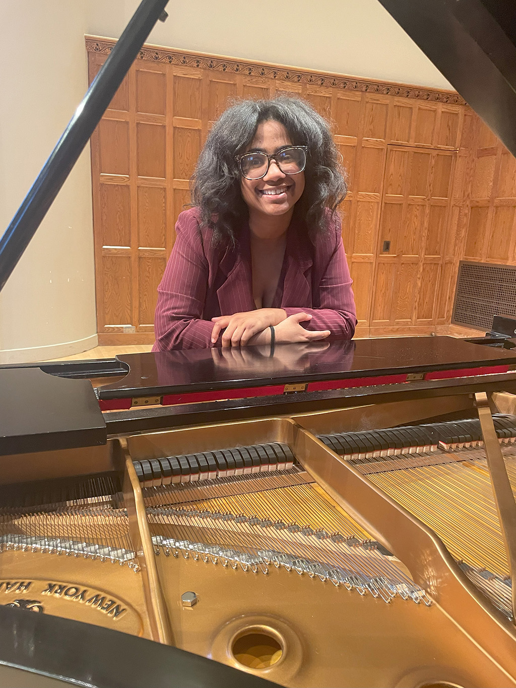 Person standing with open piano in the foreground.