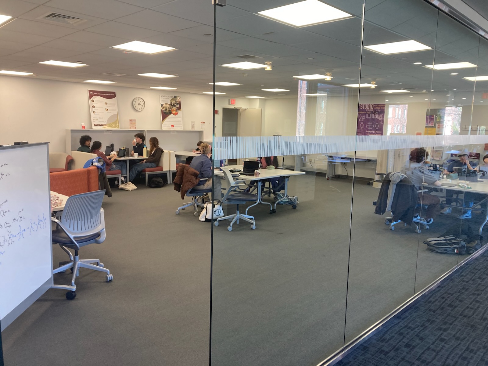 A large open room with desks with privacy dividers.