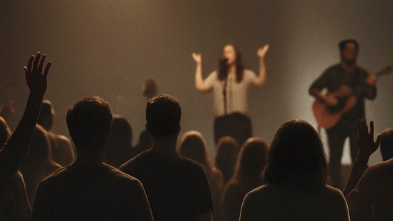Image of a singer on stage singing to an audience.