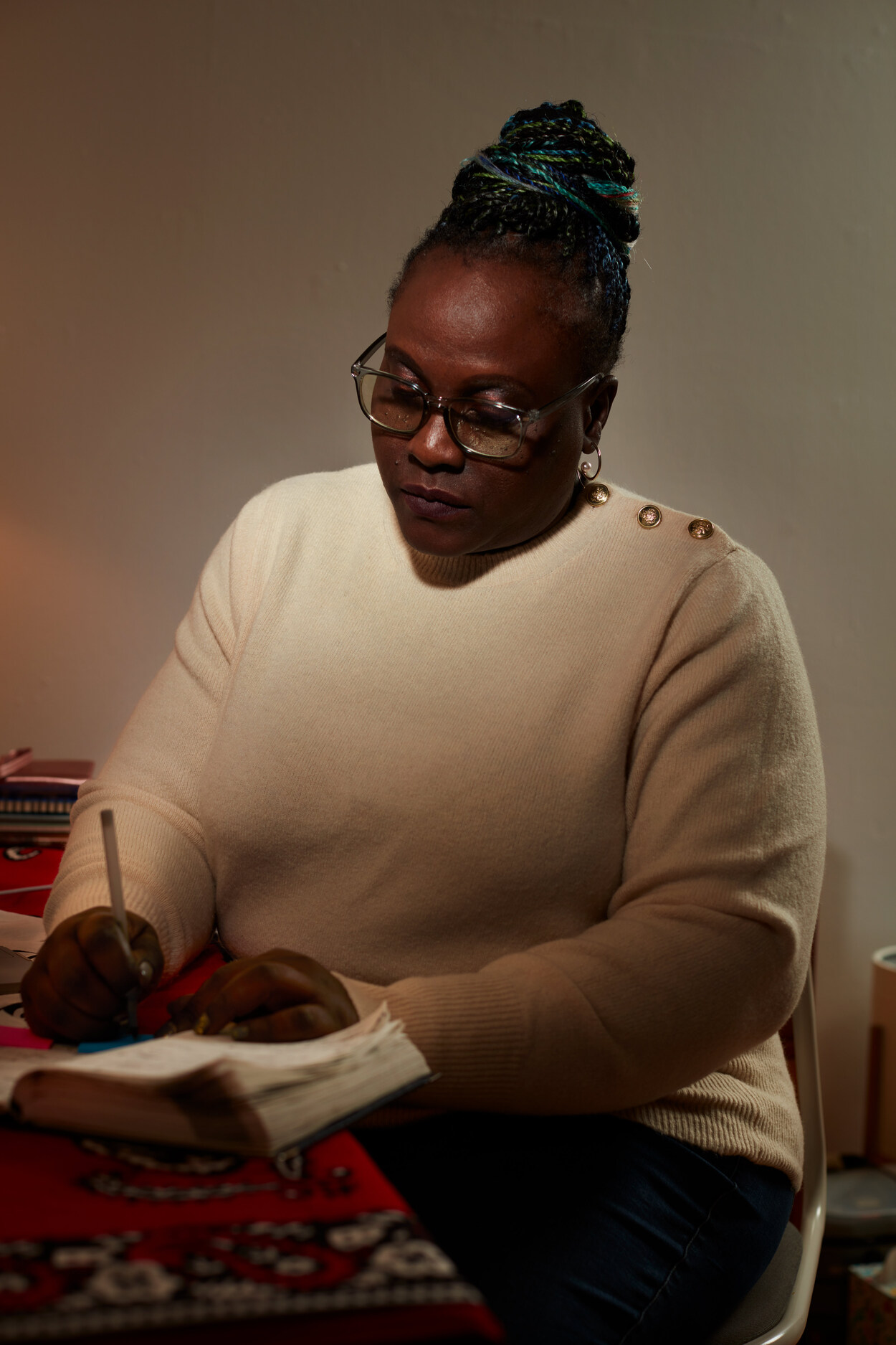 Photo of Patricia Achiro Olwoch looking down and writing in a notebook.