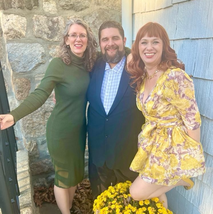 Group picture of three people smiling at the camera.