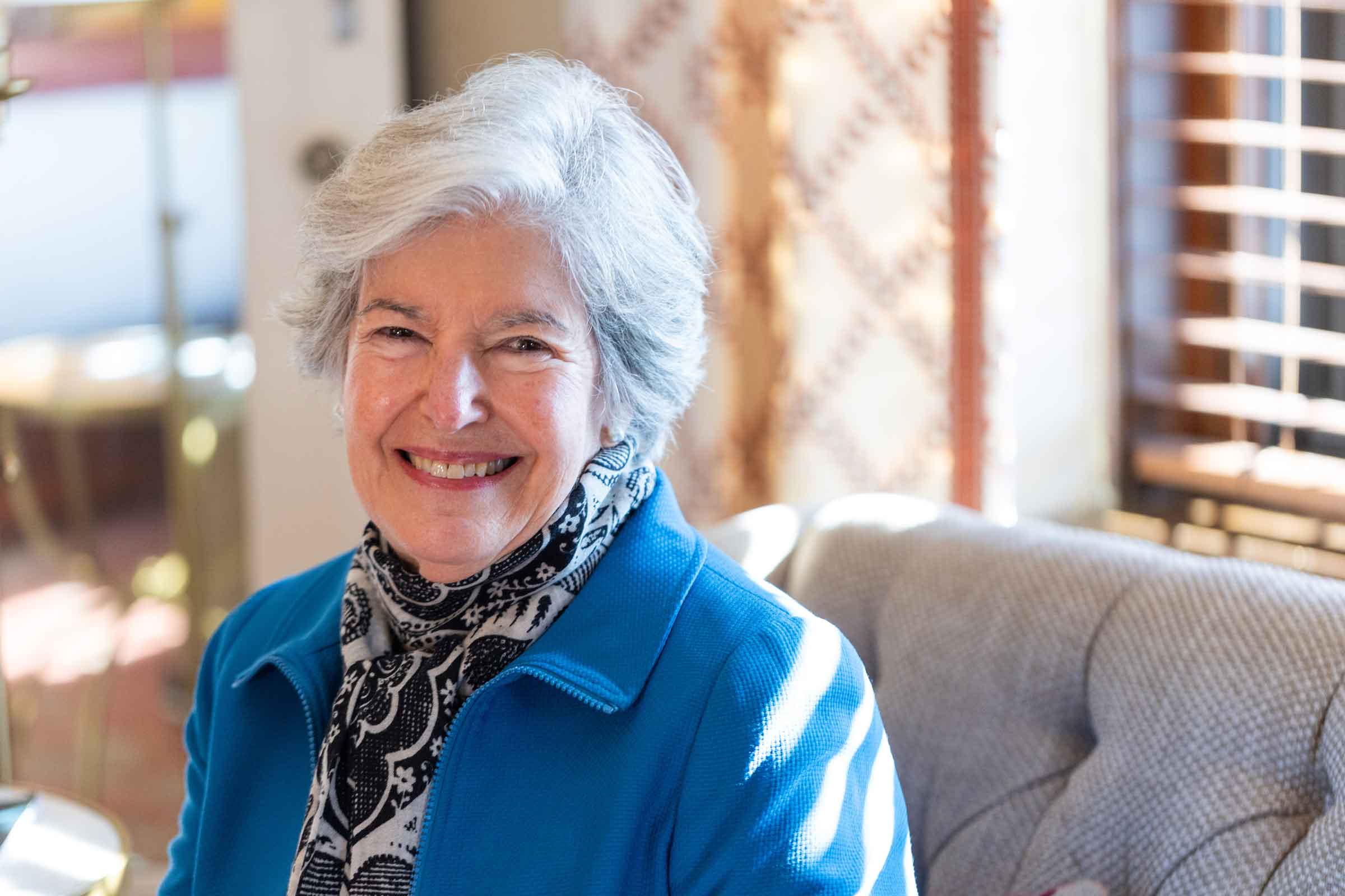 Smiling person sitting on a couch.