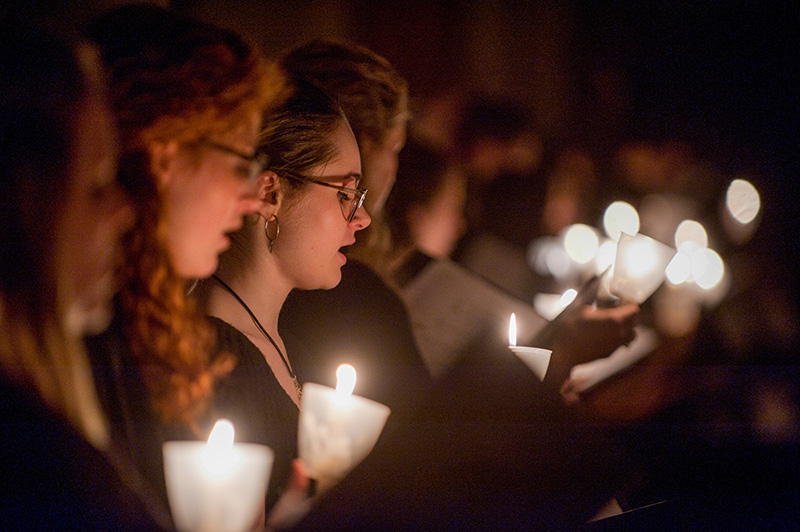 Detail of performance focussed on singers with candlight in the background.