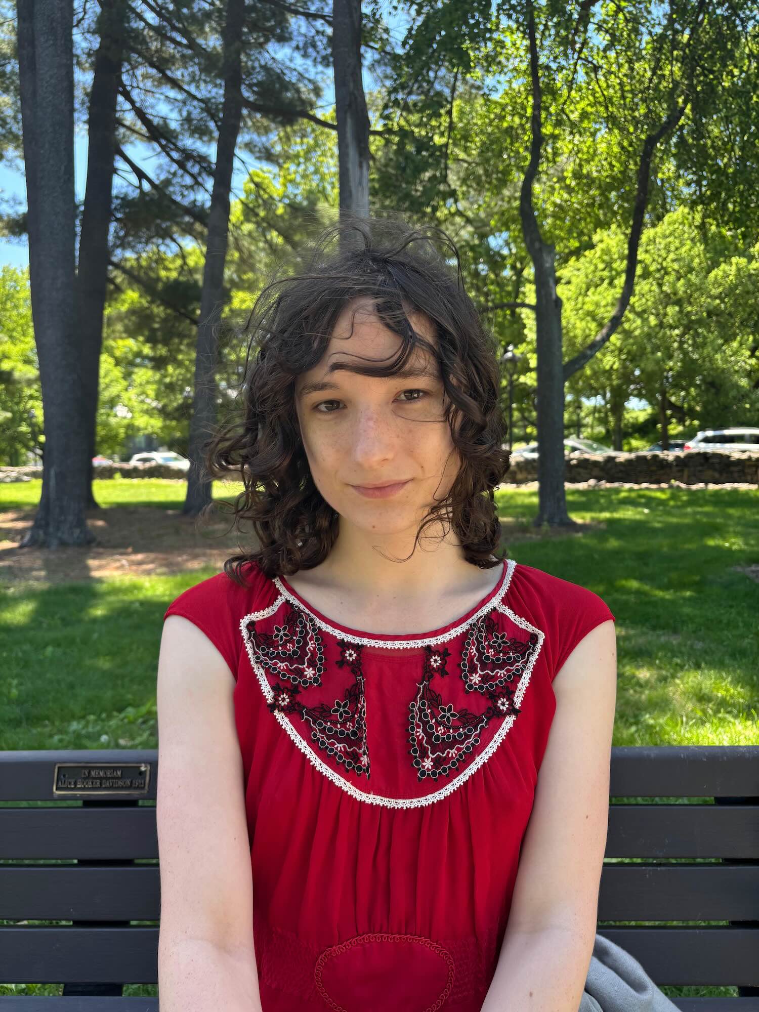 Headshot of a smiling person outdoors.