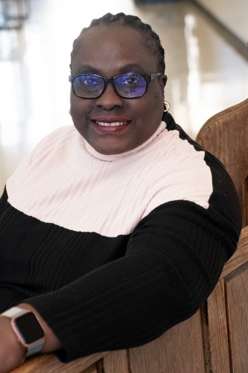 Portrait of a person sitting on a wood bench.