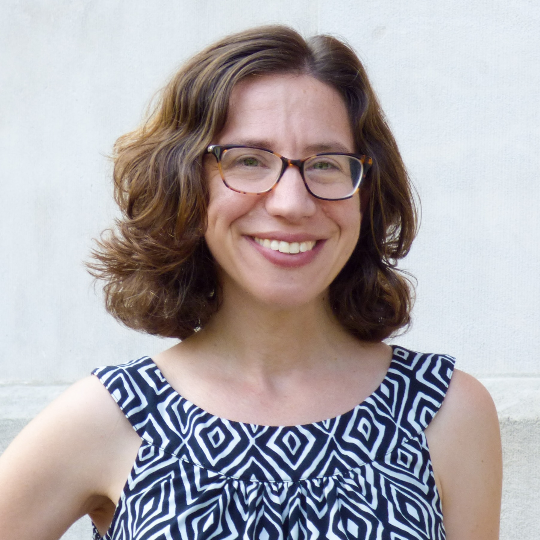 Photo portrait of a person standing in front of a white wall.