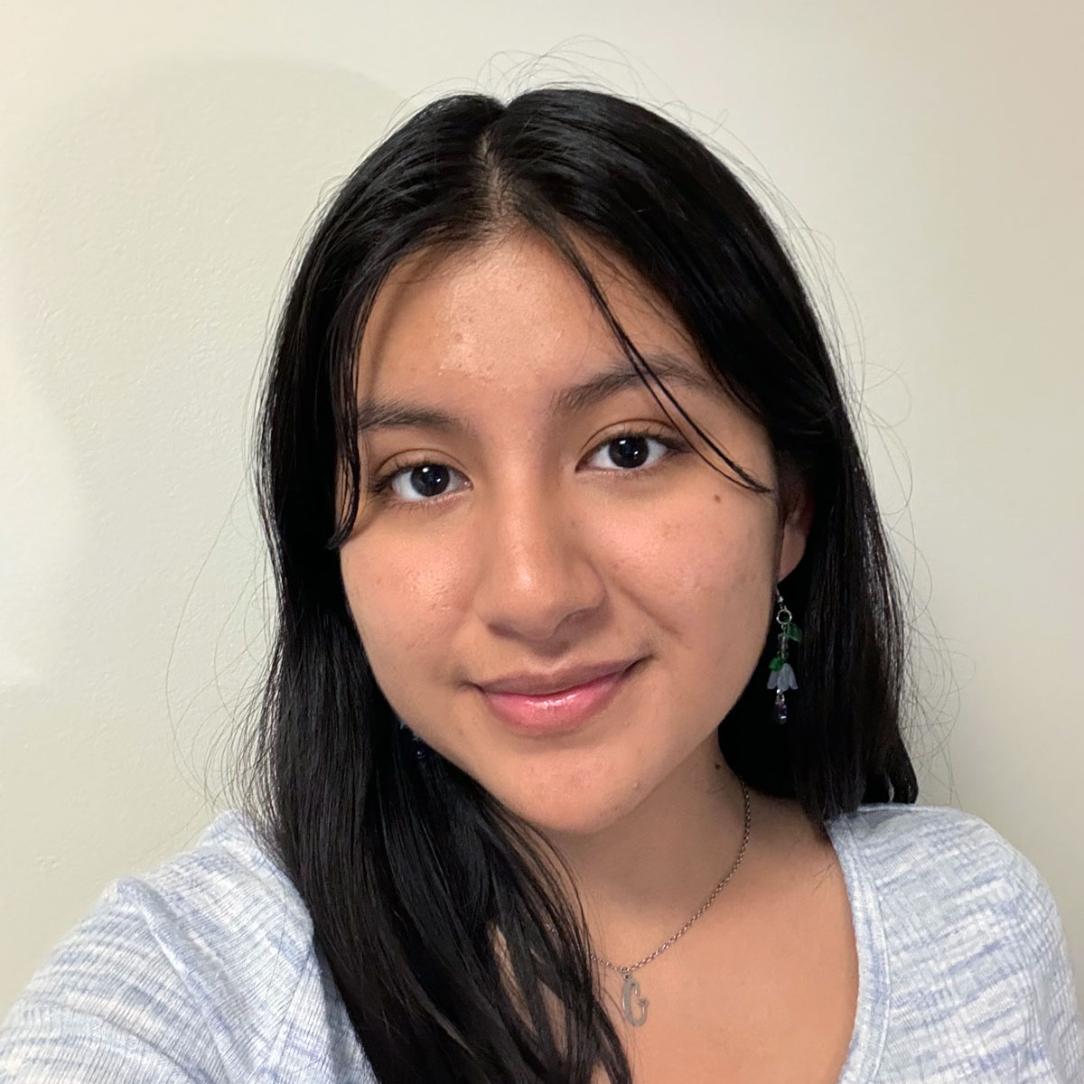 Photo portrait of a person standing in front of a white wall.