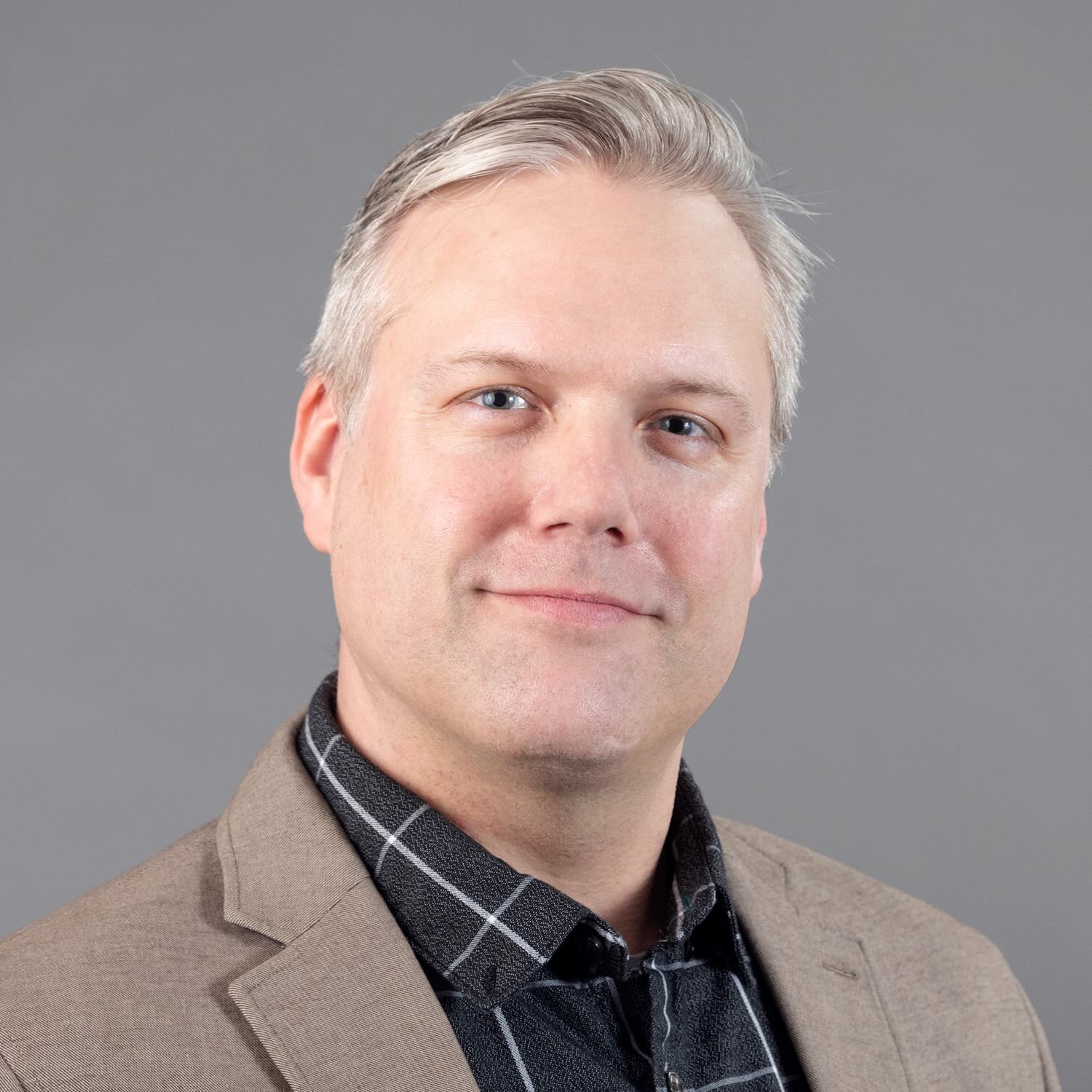 Photo portrait of a person standing in front of a grey wall.