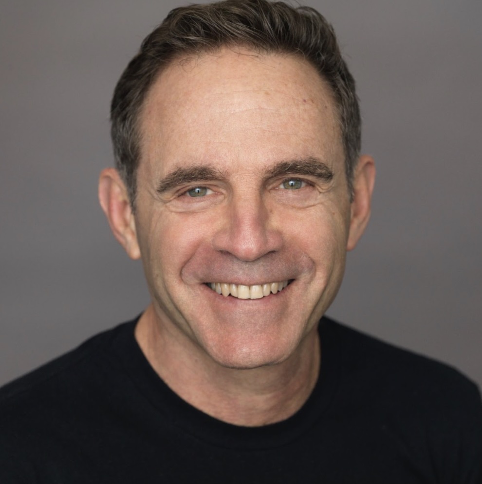 Photo portrait of a person standing in front of a grey wall.
