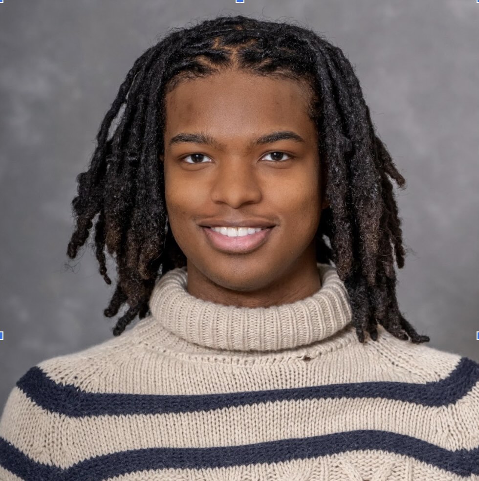 Photo portrait of a person standing in front of a grey wall.
