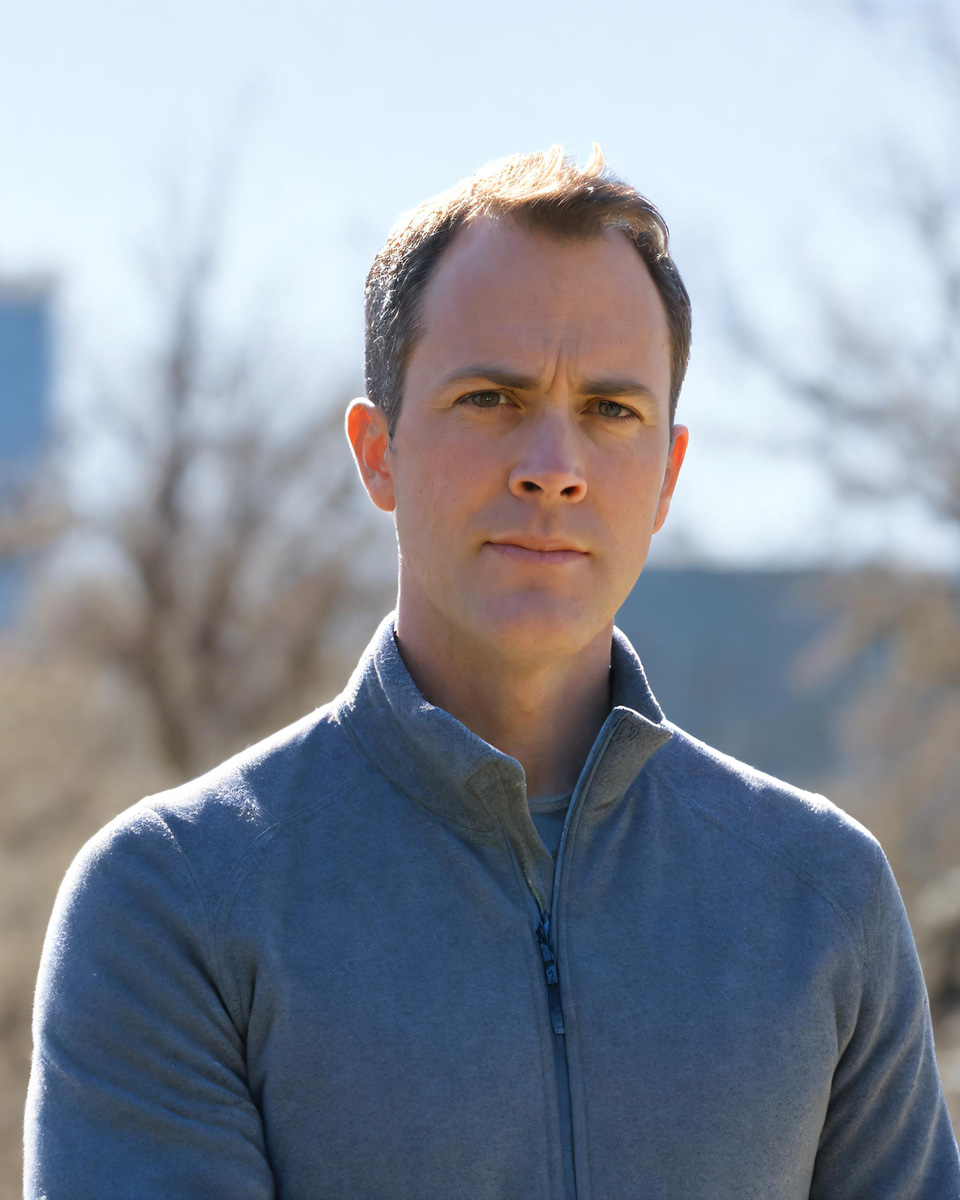 Portrait of a person standing outside during the day in a mock-turtleneck, 1/4 zip, sweater.