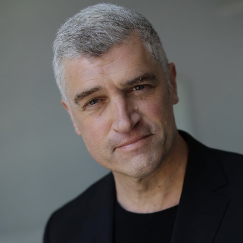 Photo portrait of a person standing in front of a grey wall.