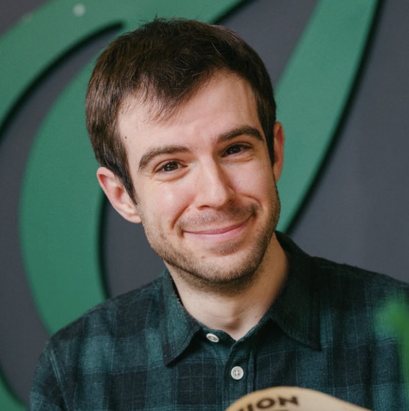 Photo portrait of a person standing in front of a dark wall.